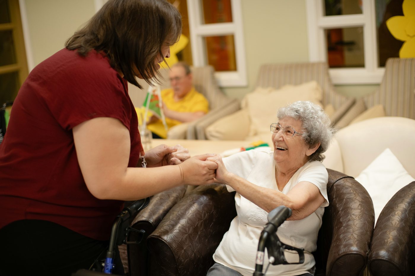 GIGI CARE caregiver holding hands with a joyful senior client